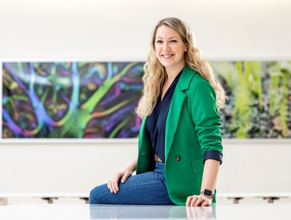 Dr. Jennifer Pahlke steht an eine Wand gelehnt da und lächelt in die Kamera.